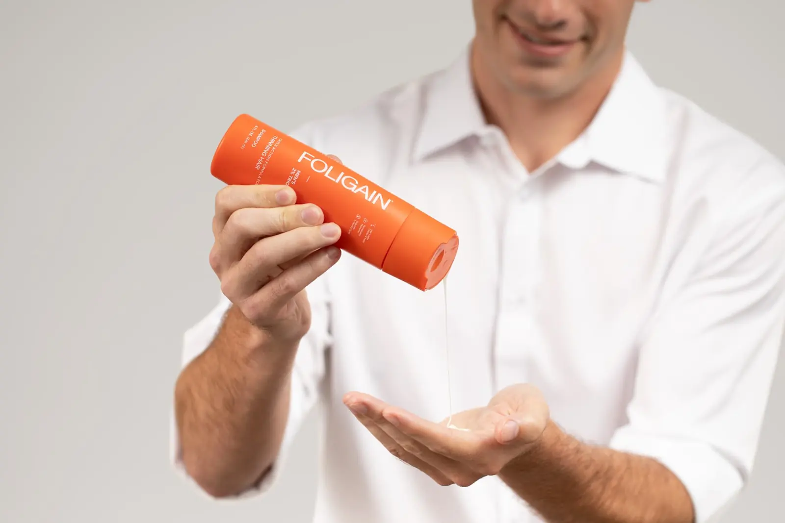 Man pouring shampoo for thinning hair