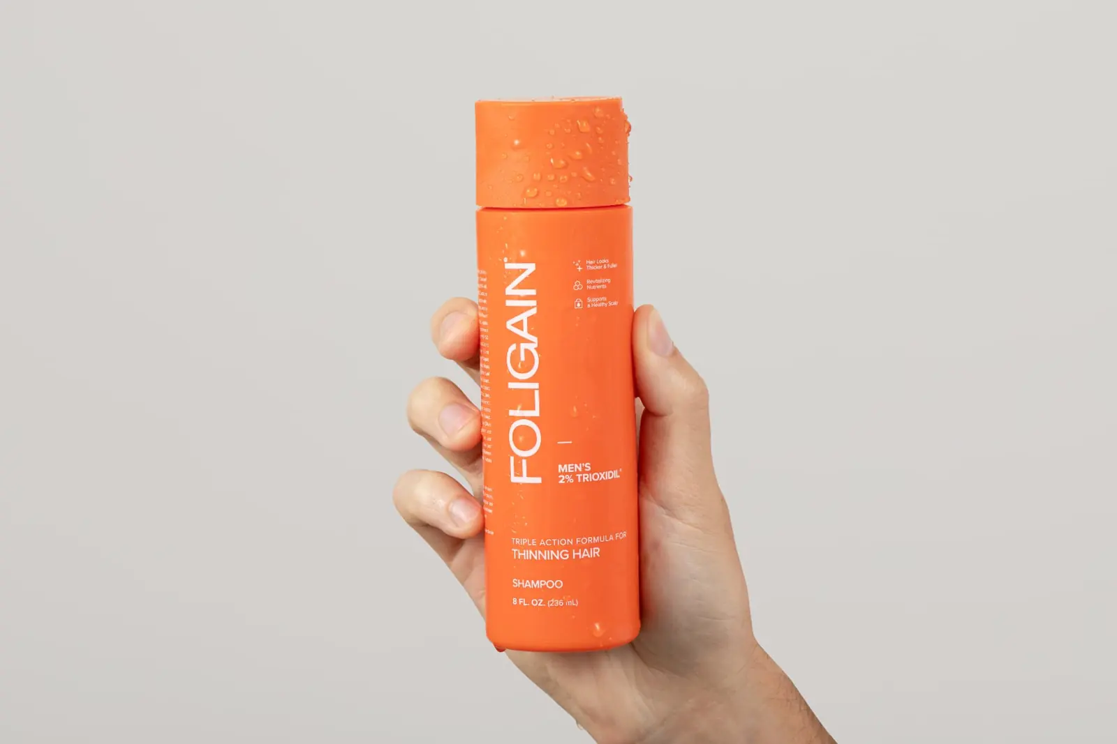 FOLIGAIN® shampoo bottle in hand