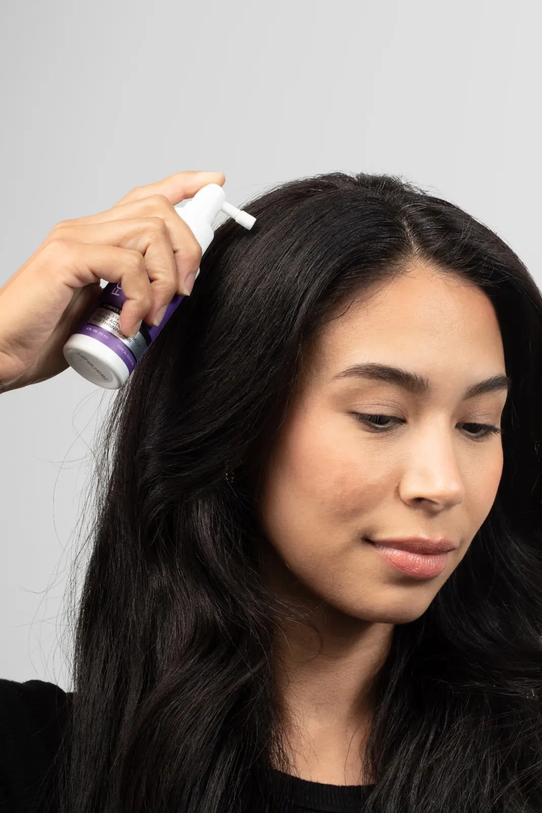 Woman applying TRIOXIDIL® to her part