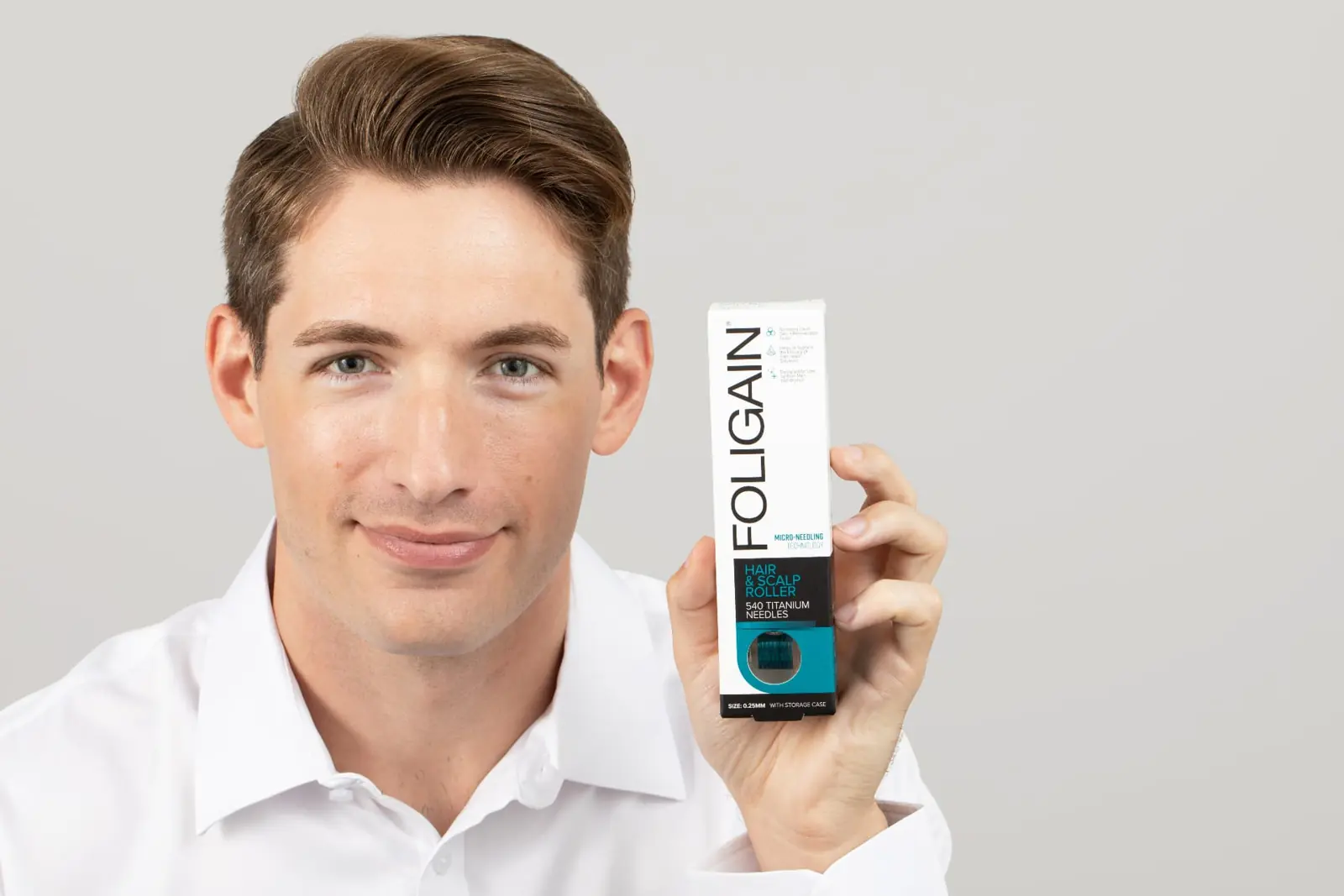 Man holding the FOLIGAIN® hair and scalp roller