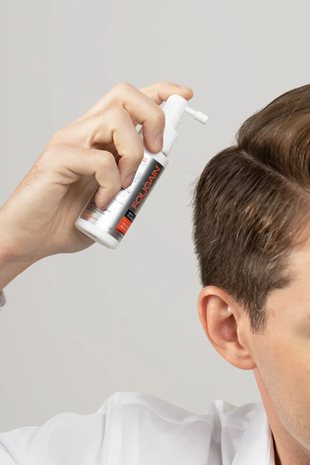 Spraying advanced regrowth treatment on the scalp
